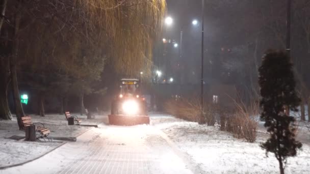 Tractorul curăță zăpada în orașul de noapte — Videoclip de stoc
