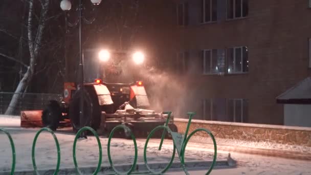 Tractor cleaning snow in the night city — 비디오