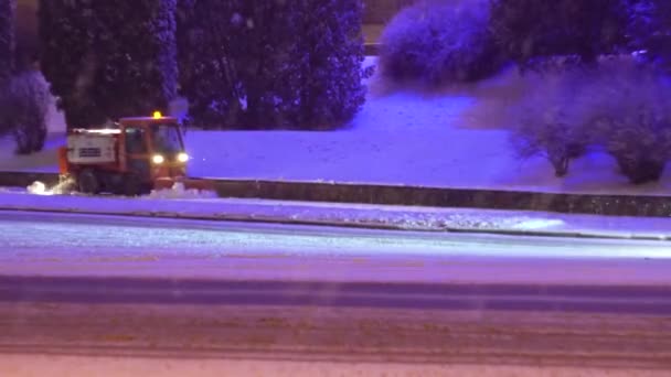 Tractor cleaning snow in the night city — Stockvideo