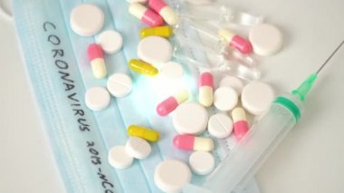 Surgical mask protective mask with CORONAVIRUS text. Virus 2019-n CoV in Wuhan, China. Tablets, mask, syringe