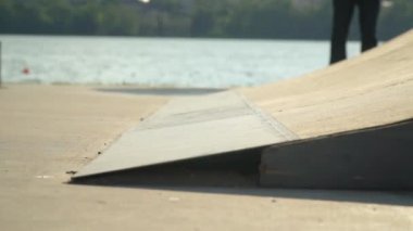 Genç patenci kaykay parkında scooter sürüyor.