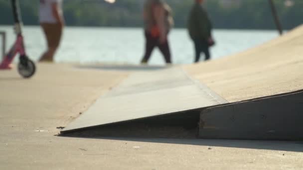 Jonge skater rijdt scooter in skatepark — Stockvideo