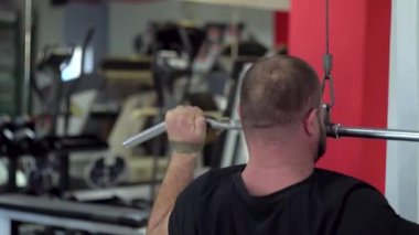 Güçlü kaslı adam spor salonunda farklı egzersizler yapar.