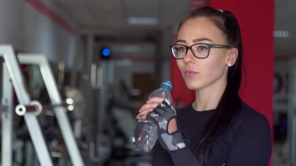 Menina bonita bebe água doce no ginásio — Vídeo de Stock