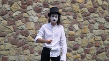 Close-up of a mime wipes her makeup in slow motion
