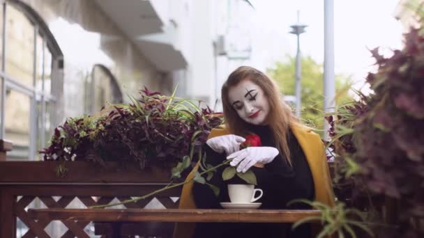 Drôle femelle mime avec fleur dans la rue café — Video