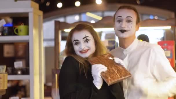 Deux mimes heureux avec une grande barre de chocolat dans le café — Video