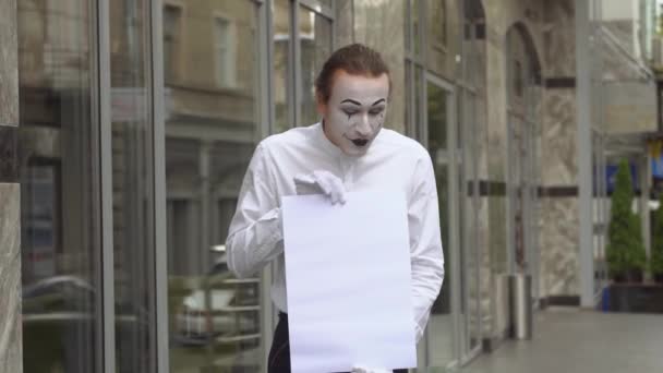 Молодой человек пантомима на улице с большим рекламным баннером — стоковое видео