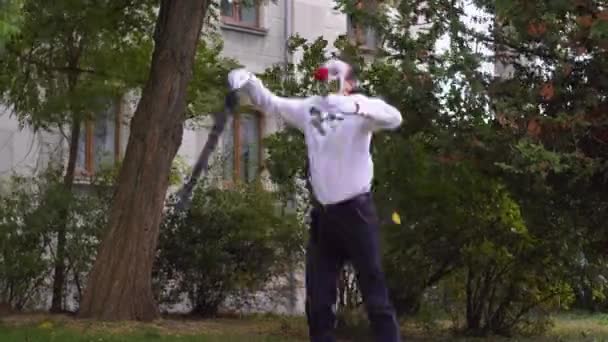 Funny mime jumps with umbrella and red flower — Stockvideo