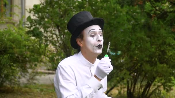 Szórakoztató pantomim fújás szappanbuborékok a szabadban lassított felvételen — Stock videók