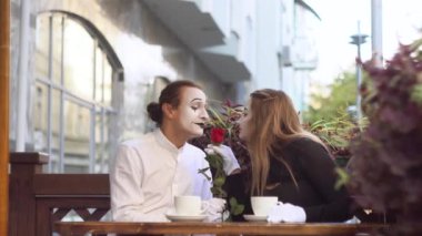Caddedeki kafede buluşan iki mutlu pandomimci. Romantik randevu