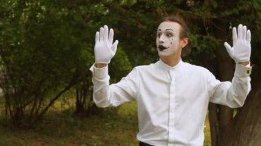 Görünmez bir cam kutunun ya da duvarın arkasındaki komik pandomimci. Parktaki pandomim gösterisi