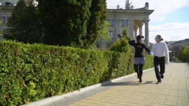 Tiyatronun yakınındaki parkta yürüyen mutlu çift. Randevuda iki mutlu pandomimci