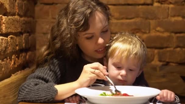 Młoda kobieta z małym chłopcem jedzącym świeżą zupę w restauracji pub — Wideo stockowe