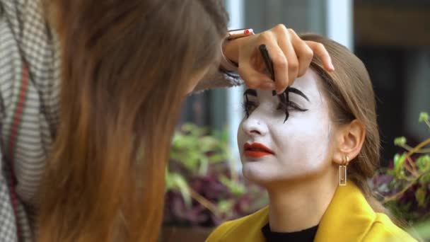 Fille peinture visage à jeune femelle mime avec crayon noir — Video