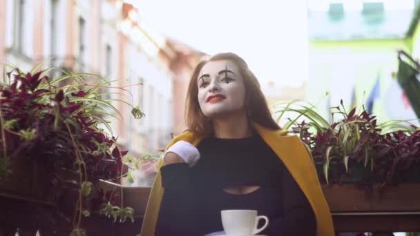 Grappige vrouwelijke mime drinken koffie in de straat cafe — Stockvideo