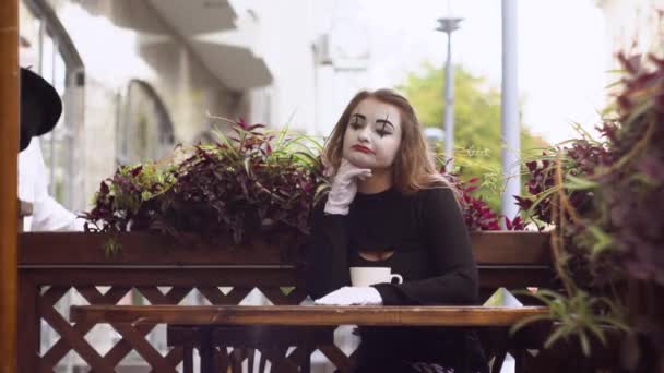 Twee gelukkige mime op een date in het café. Gelukkige man geeft een bloem aan zijn vriendin. Romantisch afspraakje — Stockvideo