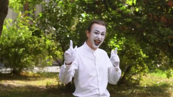 Gros plan d'un mime regardant la caméra et souriant sur fond vert dans un parc — Video