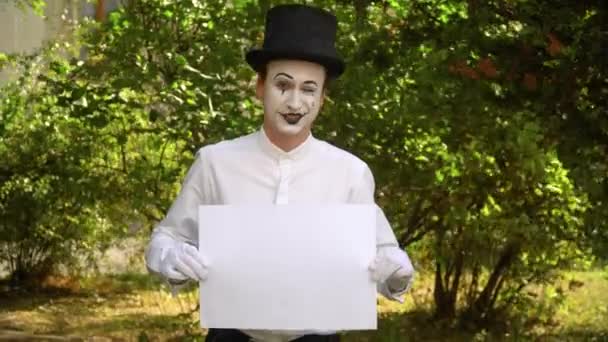 Jongeman mime in het park met grote reclame banner — Stockvideo