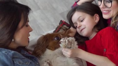 İki mutlu kadın ve köpek yatakta sarılıyor.
