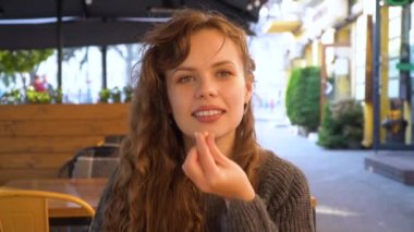 Genç bir kadın bir kafede çikolatalı kek yiyor, yakın plan.