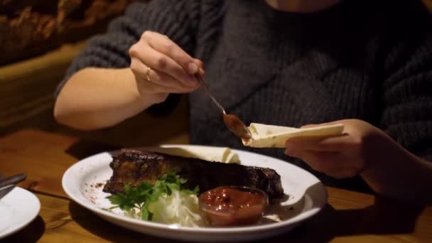 Mujer joven comiendo carne fresca en el pub del restaurante — Vídeos de Stock