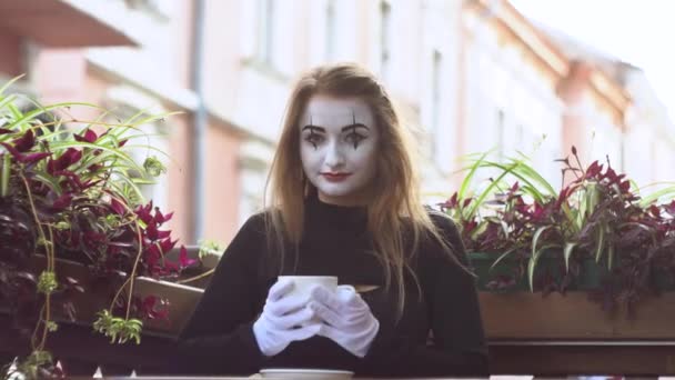 有趣的女哑剧演员在街上的咖啡店喝咖啡 — 图库视频影像