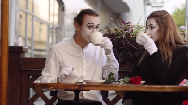 Δύο ευτυχισμένοι μίμοι σε ραντεβού πίνουν καφέ στο καφέ. Ρομαντική ημερομηνία — Αρχείο Βίντεο