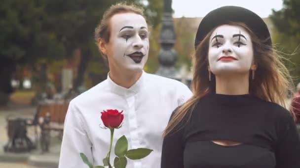 Dos mimo feliz en una cita en la calle cerca del reloj. Hombre feliz dando una flor a su novia — Vídeos de Stock