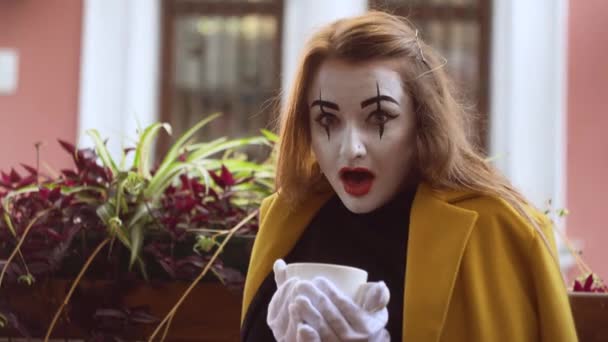 Funny female mime drink coffee in street cafe — Stock Video