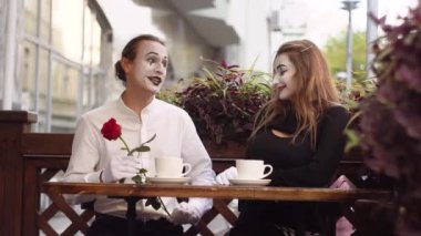 İki mutlu pandomimci kafede buluşuyor. Kız arkadaşına çiçek veren mutlu bir adam. Romantik randevu