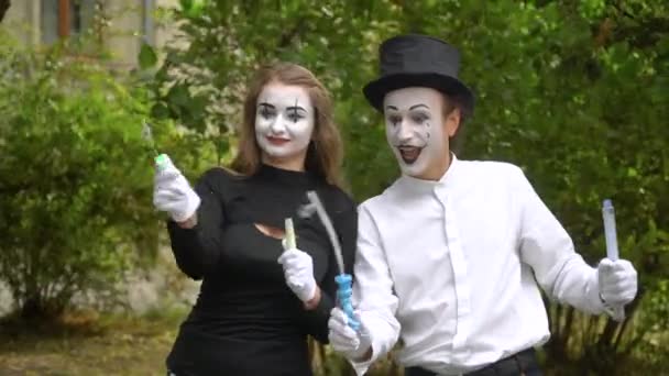 Dois jovens mimes engraçados soprando bolhas de sabão ao ar livre — Vídeo de Stock