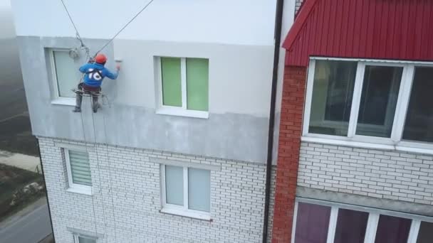 Przemysłowy alpinista maluje elewację nowego budynku — Wideo stockowe