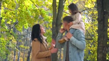 Babasının sırtındaki çocuk. Autumn Park 'ta mutlu bir aile. Düş