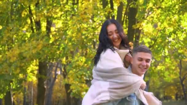 Laughing joyful family. Happy couple having fun in the autumn park — Stock Video