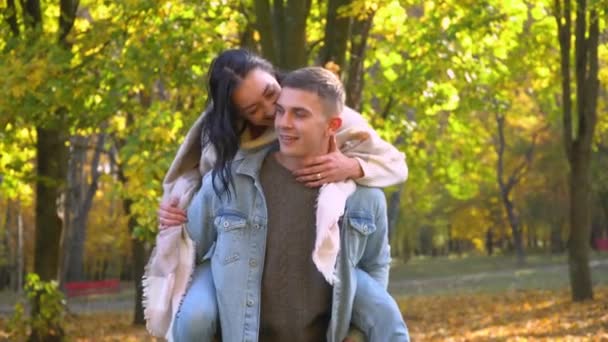 Riendo familia alegre. Pareja feliz divirtiéndose en el parque de otoño — Vídeos de Stock