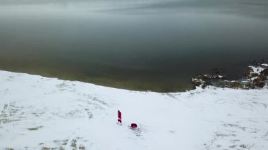 Noel Baba, okyanusun karlı kıyıları boyunca hediye dolu bir çantayla kızak çeker. Üst görünüm
