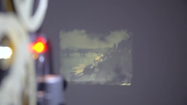 Film berjalan melalui proyektor 8mm. Proyektor tua menunjukkan film dengan Praha tua 60-an — Stok Video