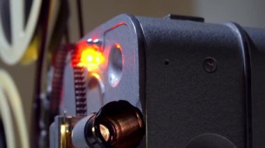 Film 8 mm 'lik bir projektörden geçiyor. Eski projektör bir film gösterir