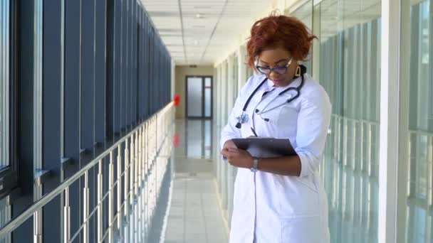 在医院的非洲裔美国医生的近照。住院女医生记录，特写镜头 — 图库视频影像