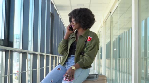 Africká americká dívka čekají na nástup a odjezd na letišti a telefonování — Stock video