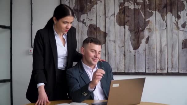 Bedrijfsleider gebruikt laptop, raadpleegt zijn secretaresse — Stockvideo