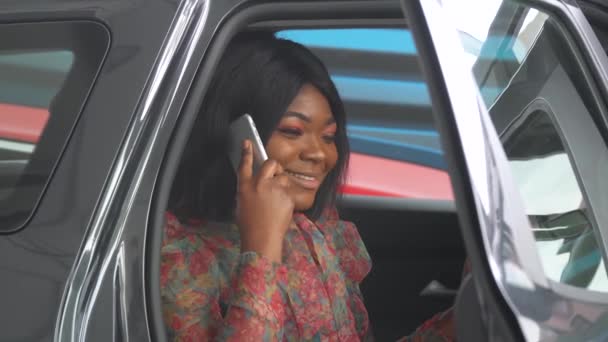 Femme d'affaires afro-américaine parlant au téléphone alors qu'elle était assise dans une voiture. La voiture est noire — Video