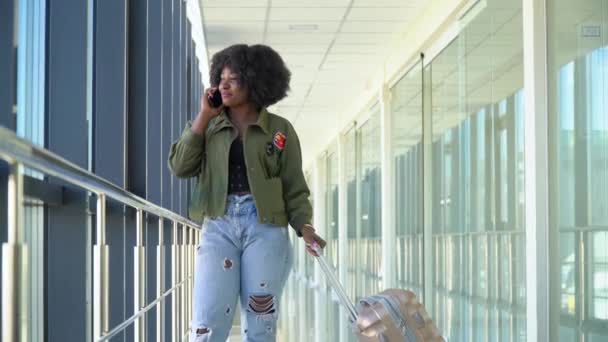 Menina afro-americana estão esperando para embarcar e partir no aeroporto e falar ao telefone — Vídeo de Stock