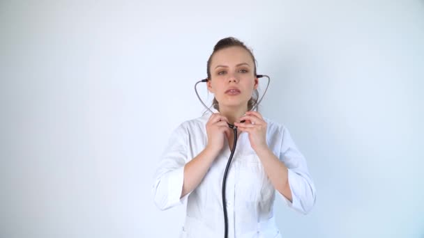 Dokter vrouw in een witte jas met een stethoscoop in het ziekenhuis. Ontvangst van een patiënt met longontsteking — Stockvideo