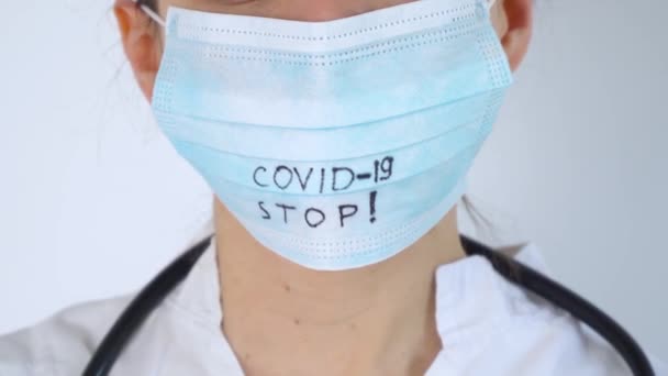 Крупный план кавказского врача со стетоскопом в защитной маске. Защита Covid-19. Остановить коронавирус — стоковое видео