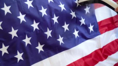 Bir kadın buharlı ütüyle Amerikan bayrağını okşuyor. ABD Gazi Günü Hazırlıkları