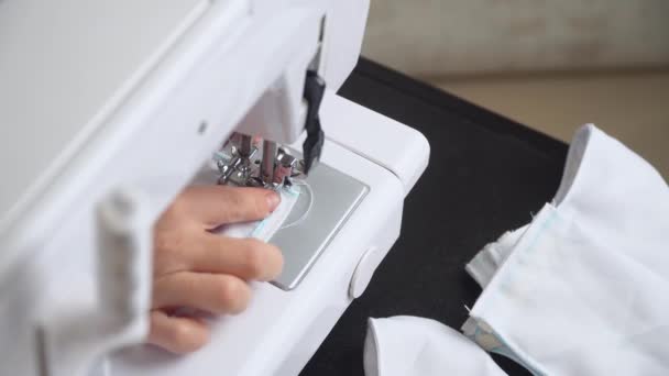 Woman sews a protective mask. Making cotton fabric medical mask, coronavirus protection. Quarantine lesson — Stock Video