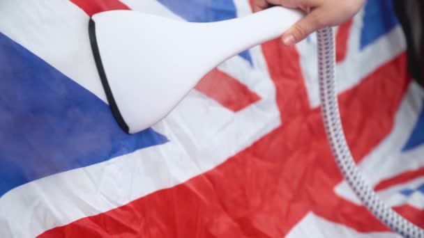 Mujer planchando bandera del Reino Unido con plancha de vapor. Preparación para el Día de la Mancomunidad — Vídeo de stock