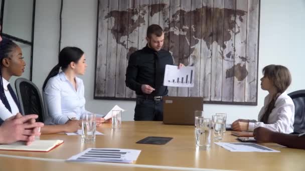 Business coach gives corporate presentation for businesspeople in office, dark skinned businessman presents new business plan, speaking to clients — Stock Video